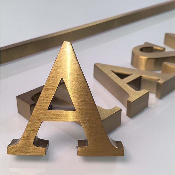 Dimensional gold letters mounted on a wall as a company logo sign